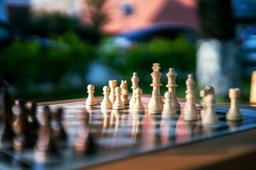 Black and white chess pieces set up on an outdoor chessboard, ready for an intellectual game....