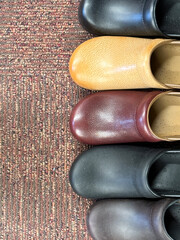 Row of various leather clogs