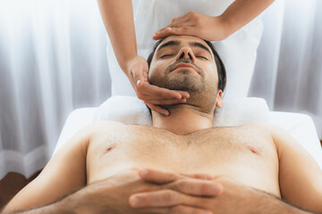 Caucasian man enjoying relaxing anti-stress head massage and pampering facial beauty skin...