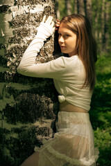 Woman leaning on tree in forest