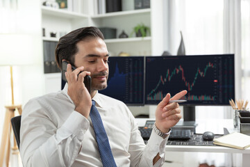 Trader businessman calling to consultant or partner with two stock exchange investment, compare...