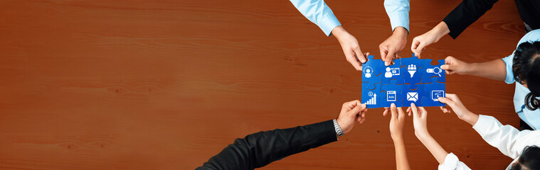 A diverse group of professionals collaborates on a digital marketing strategy. Their hands hold...