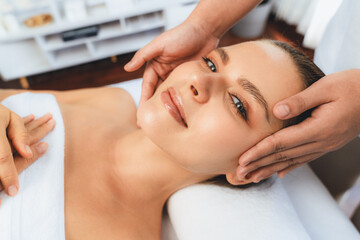 Caucasian woman enjoying relaxing anti-stress head massage and pampering facial beauty skin...