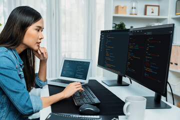 Young Asian in IT developer creating with typing online information on pc with coding program data...
