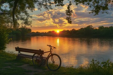 Obraz premium Bicycle resting on beachfront bench at riverside during stunning sunset, Bicycle at Riverside Sunset, outdoors
