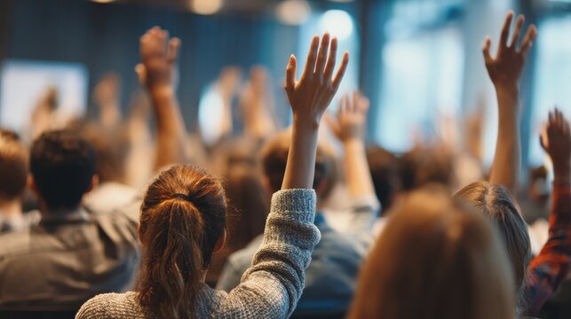 Group of young people sitting on conference together while raising their hands to ask a question. Business team meeting seminar training concept., no logos, no brands