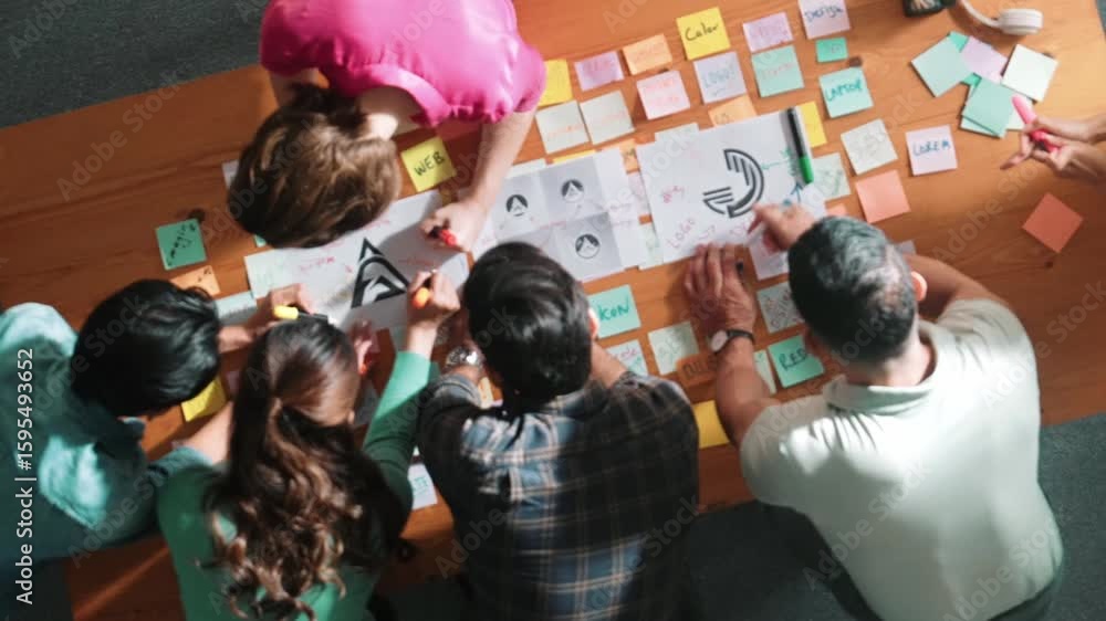 Poster top down aerial view of skilled designer hold logo while discuss with team. aerial business group wo