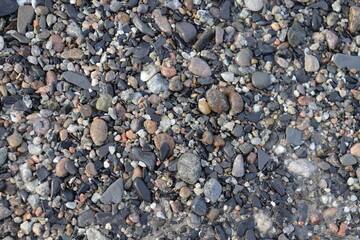A background with pebble stones. Nature background with little rocks. Close-up of stones on the beach. Zen and natural. 