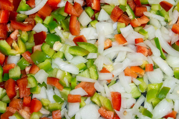 Preparado de pimiento rojo, pimiento verde, cebolla y ajo para guiso de comida de dieta mediterránea sana y fresca.