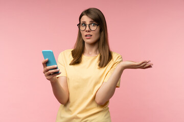 Confused young woman in glasses holding a smartphone with puzzled expression, reacting to betting...