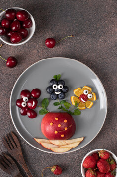 Naklejki Fun food idea for kids - vase with flowers from berries laid out on gray plate, Top view