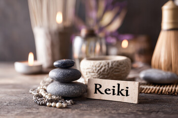 Reiki healing session setting with stacked stones, candles and incense sticks promoting relaxation