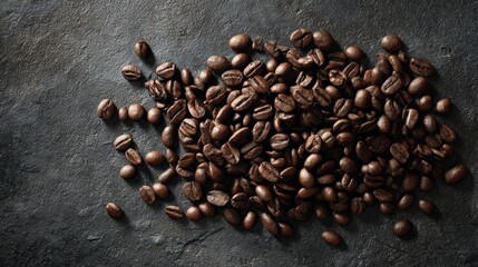 Dark Roasted Coffee Beans Spread on a Textured Stone Surface