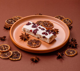 Nougat or white caramel with hazelnuts and pistachios and citrus pieces. White nougat with nuts