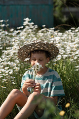 The boy is wearing a striped T-shirt and a bouquet of daisies. He has a hat on his head.
