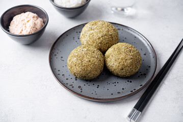Rice balls with filling and greens topping in a plate