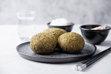 Rice balls with filling and greens topping in a plate