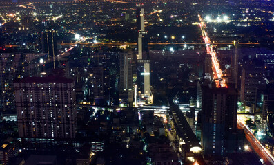 An ethereal nocturnal city panorama, adorned with twinkling lights from towering buildings and blurred highways, under a dark sky in Bangkok, Thailand. 