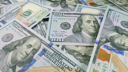 A detailed closeup view of a stack of U.S. Hundred Dollar Bills that are piled closely together