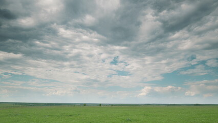A Serene Landscape Featuring a Cloudy Sky Above Expansive Green Fields All Around Time lapse.