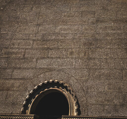 Round Arch Window in Stone Wall with Decorative Stonework and Shadow Play