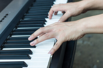 Fototapeta premium Piano keys and human hands close-up