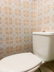 interior of bathroomwhite toilet lined with pattern of white vintage tiles