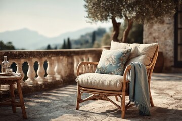 Fototapeta premium Comfortable outdoor chair with a decorative pillow on a sunny terrace overlooking mountains in the afternoon