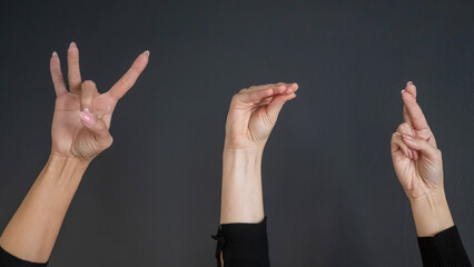 Russian Sign Language. Close-up of hands on black background. 