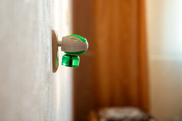 Mosquito repellent with plug into the socket at home closeup. Domestic electric raptor fumigator...
