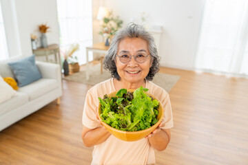 Happy Asian senior woman enjoy healthy lifestyle cooking and eating organic fresh clean food at...