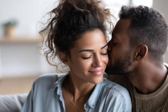 Young Latina couple sharing tender moments in a cozy home environment exploring affection and intimacy