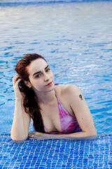 Relaxed young woman enjoying a day at the pool in summer