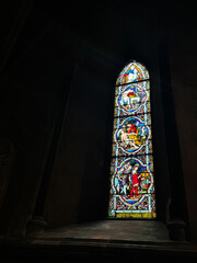 Colorful Stained Glass Window in Dimly Lit Historic Church Interior