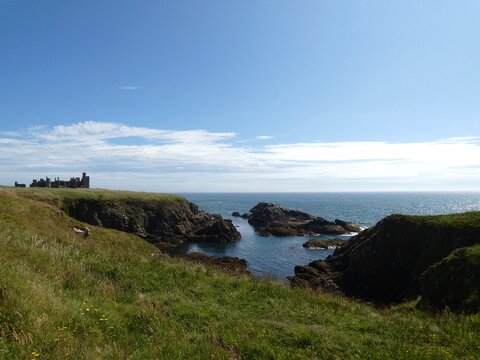 A rugged rocky coastline with jagged dark rocks - Powered by Adobe