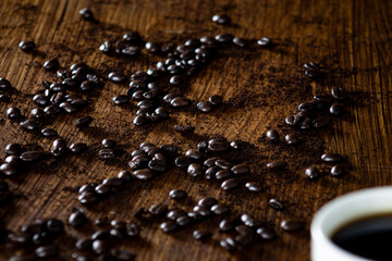 Roasted Coffee Beans with Cup on Wooden Table