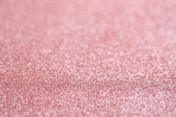 Beautiful pink glitter sparks texture as background with shallow depth of field