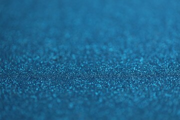 Beautiful blue glitter sparks texture as background with shallow depth of field