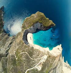 Boats bob in turquoise water near the shore of the iconic beach. A winding path leads up the...