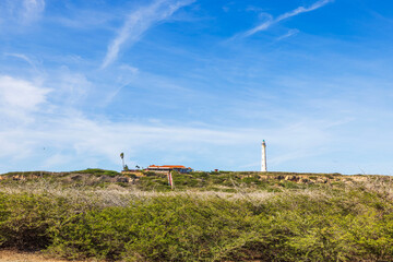 California Lighthouse with nearby restaurant and miniature museum on desert hill in Aruba.