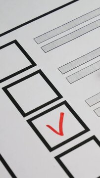 Voter marks box with red marker next to candidate on paper ballot. Democratic elections background. Electoral process ensures fair representation. Secure voting system guarantees democratic engagement