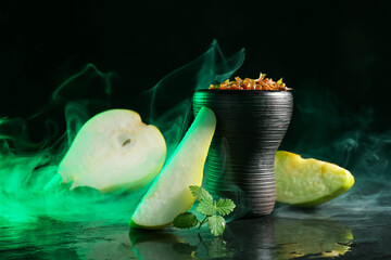 Hookah bowl with pear pieces, mint and smoke on black table, closeup