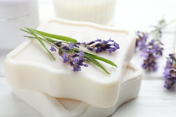 Soap bars and lavender flowers on white table, closeup