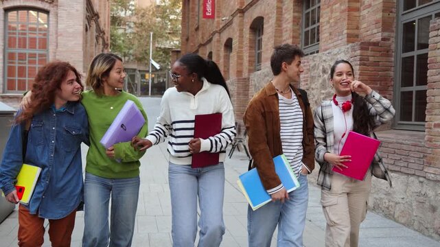 A joyful group of students is walking and chatting with enthusiasm while holding colorful folders and notebooks. Their camaraderie reflects the spirit of youth and friendship in an educational setting