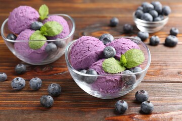 Tasty sorbet with blueberries and mint served on wooden table, closeup