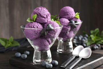 Tasty sorbet with blueberries and mint in dessert bowls on wooden table, closeup