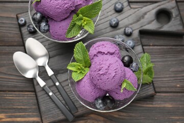 Tasty sorbet with blueberries and mint in dessert bowls on wooden table, top view