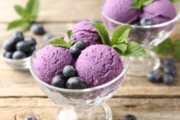 Tasty sorbet with blueberries and mint in dessert bowls on wooden table, closeup