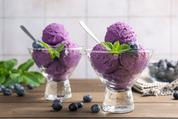 Tasty sorbet with blueberries and mint in dessert bowls on wooden table, closeup