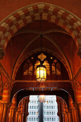 Upward view of ornate archway entry leading to vaulted ceiling with hanging lantern; framed view of...